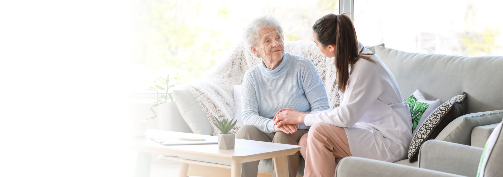 senior woman and caregiver smiling at each other